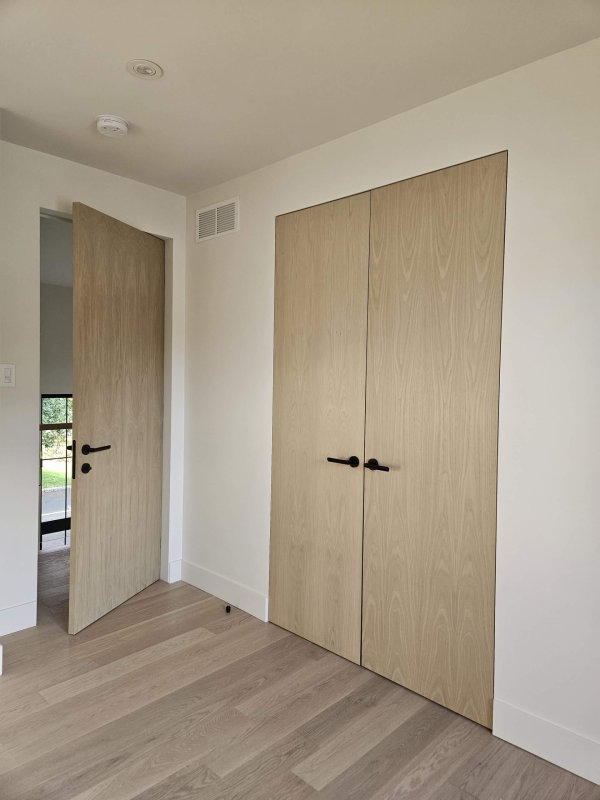 Porte intérieure en bois de qualité supérieure avec poignée en métal, fabriquée par Dorr Industries.